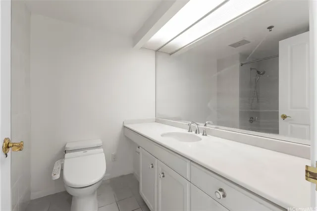 a bathroom with a granite countertop sink a toilet and a mirror