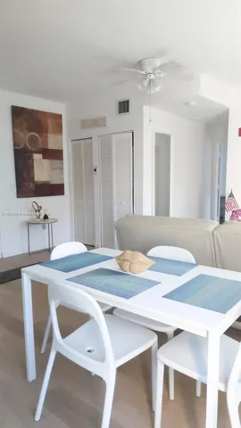 a dining hall with stainless steel appliances granite countertop a sink a stove a dining table and chairs