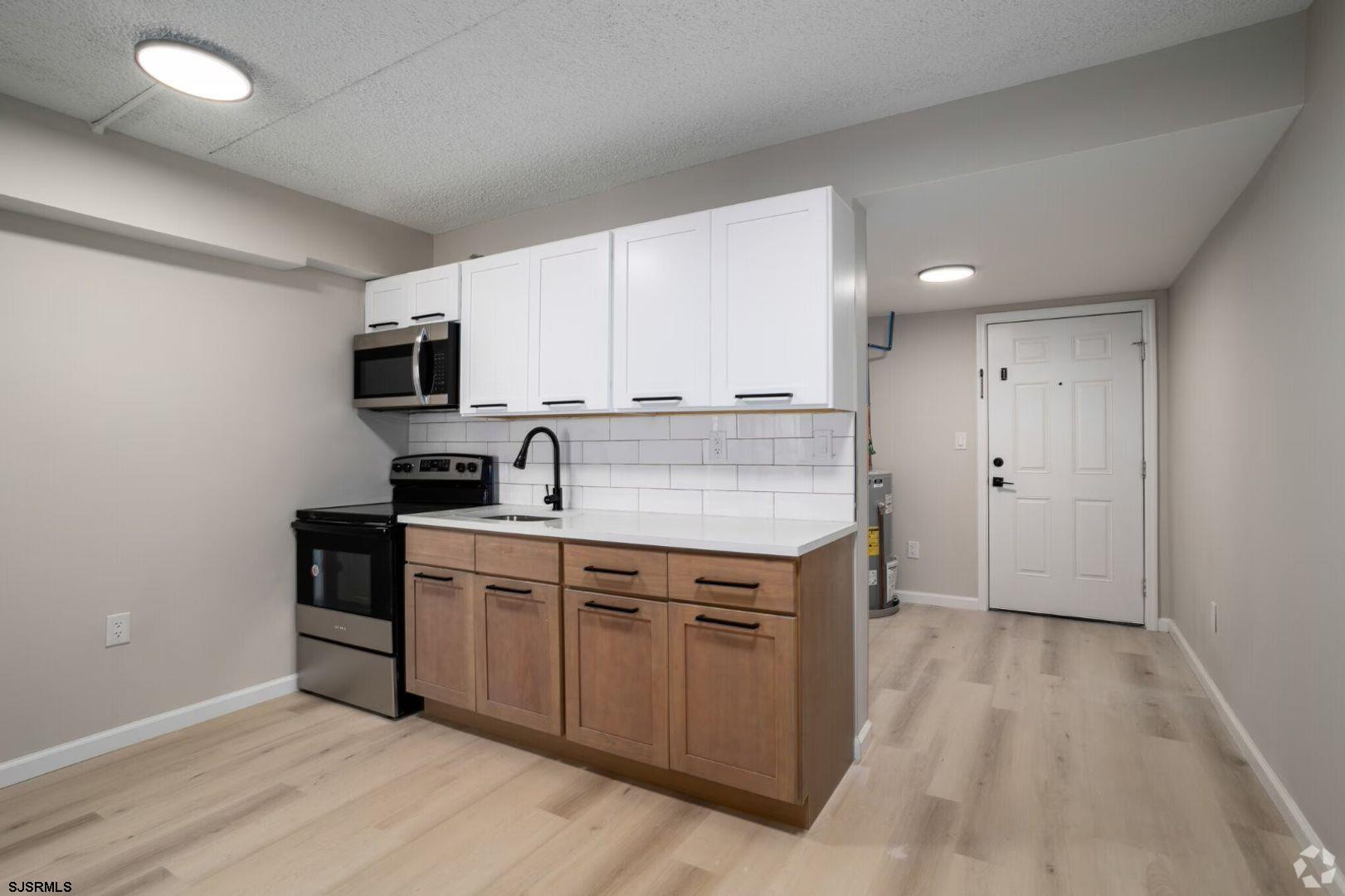 2580 Tilton Road, Unit 34 Egg Harbor Township, NJ 08234 - Photo 7 of 12 a kitchen with a sink cabinets and wooden floor
