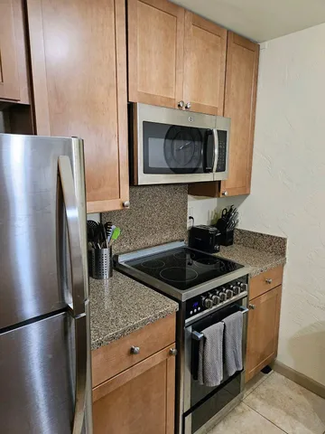 a kitchen with stainless steel appliances granite countertop a stove a refrigerator and a microwave