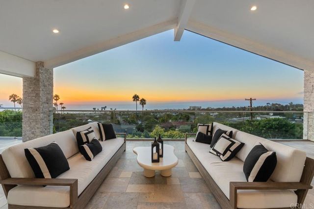 a view of a patio with couches table and chairs with wooden floor and fence