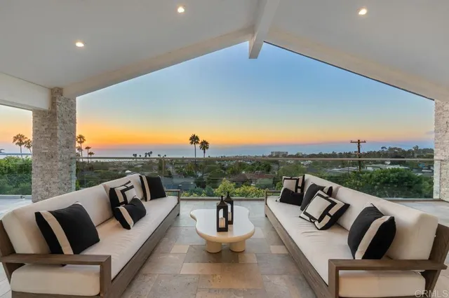 a view of a patio with couches table and chairs with wooden floor and fence