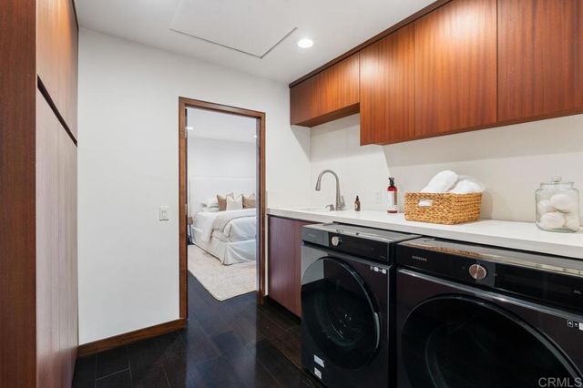 a room with a potted plant and kitchen view