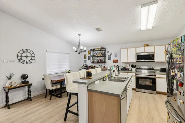 a kitchen with a sink a stove and chairs