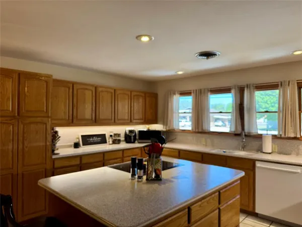 a kitchen with a sink chairs and cabinets
