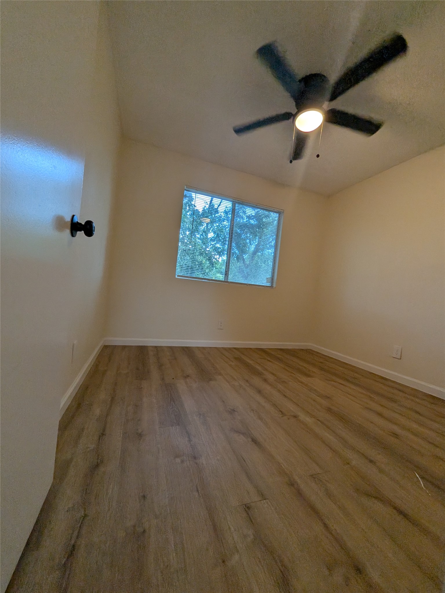 13303 Lyndhurst Street, Unit B Austin, TX 78729 - Photo 11 of 13 A quiet bedroom featuring resilient wood-look flooring and a modern ceiling fan.