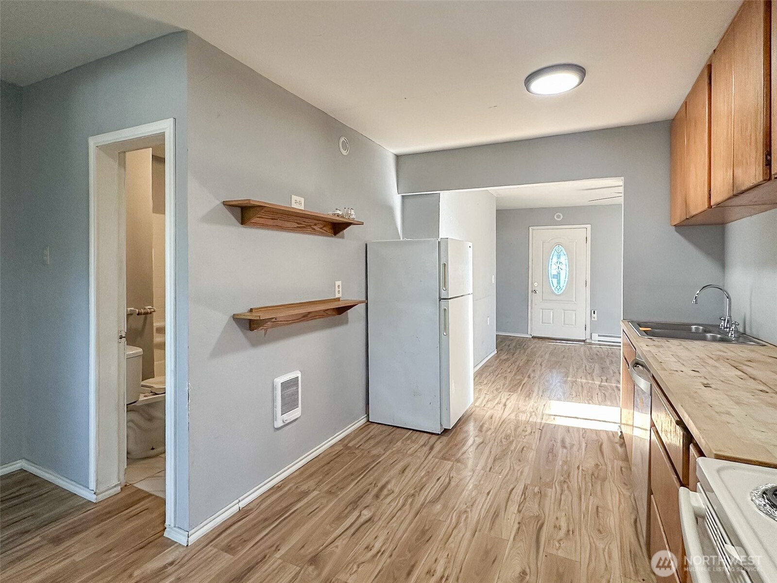 1222 West Schley Street Aberdeen, WA 98520 - Photo 14 of 31 a view of a kitchen from the hallway with a wooden floor