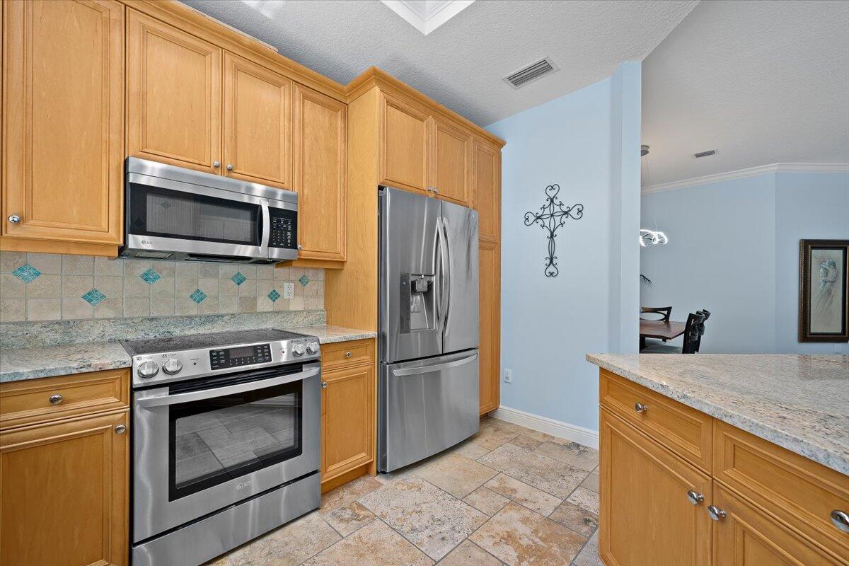 455 Ocean Ridge Way Juno Beach, FL 33408 - Photo 11 of 45 a kitchen with granite countertop a stove microwave and refrigerator