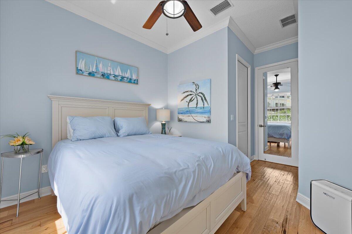 455 Ocean Ridge Way Juno Beach, FL 33408 - Photo 21 of 45 a bedroom with a bed and a chandelier