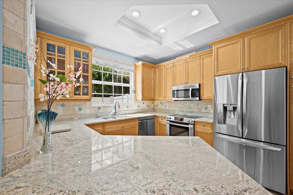 455 Ocean Ridge Way Juno Beach, FL 33408 - Photo 10 of 45 a kitchen with stainless steel appliances granite countertop a refrigerator a stove top oven a sink and dishwasher