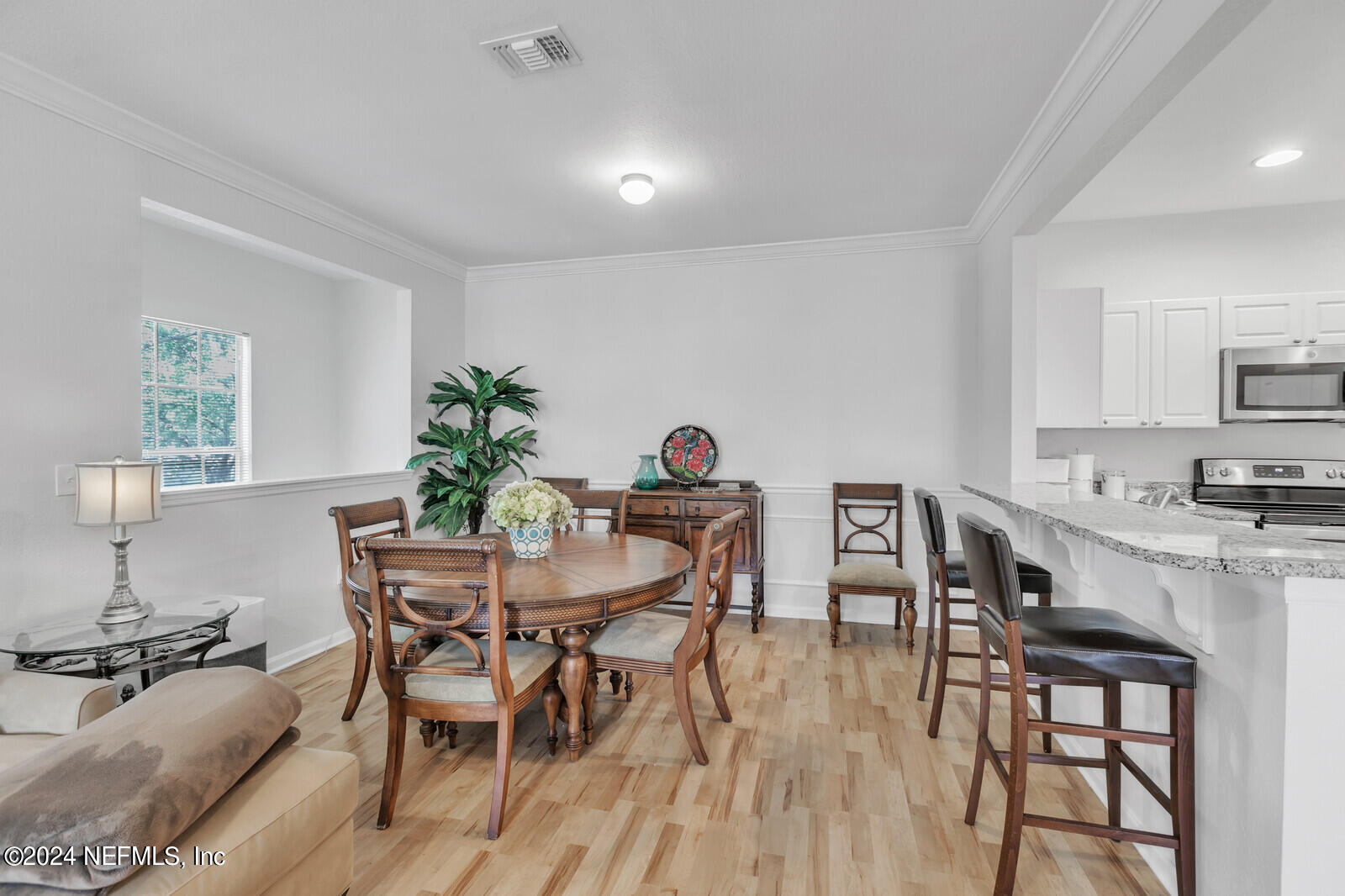 10901 Burnt Mill Road, Unit 2106 Jacksonville, FL 32256 - Photo 5 of 23 a view of a dining room with furniture and wooden floor