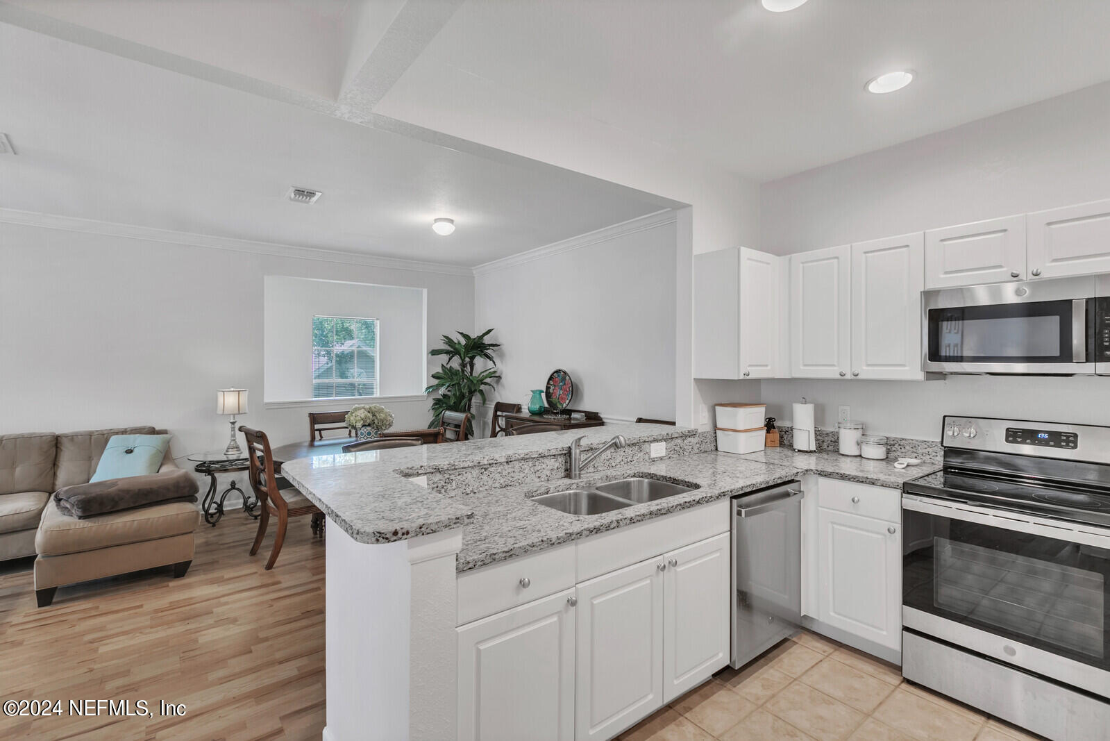 10901 Burnt Mill Road, Unit 2106 Jacksonville, FL 32256 - Photo 7 of 23 a kitchen with granite countertop a sink and white cabinets
