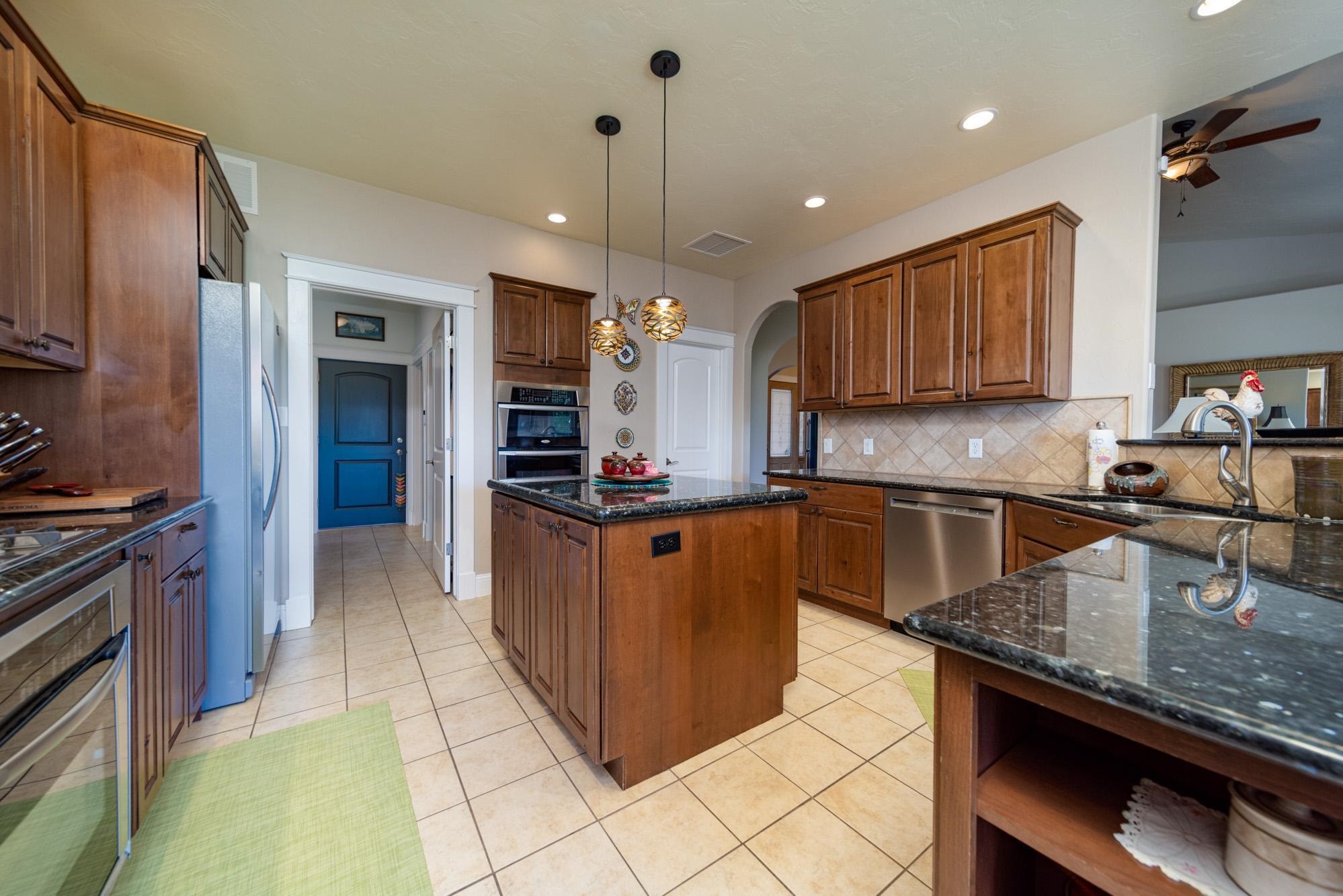 1371 Saddle Ridge Road Loma, CO 81524 - Photo 11 of 42 a kitchen with stainless steel appliances granite countertop a stove a sink dishwasher a refrigerator and a oven with wooden floor