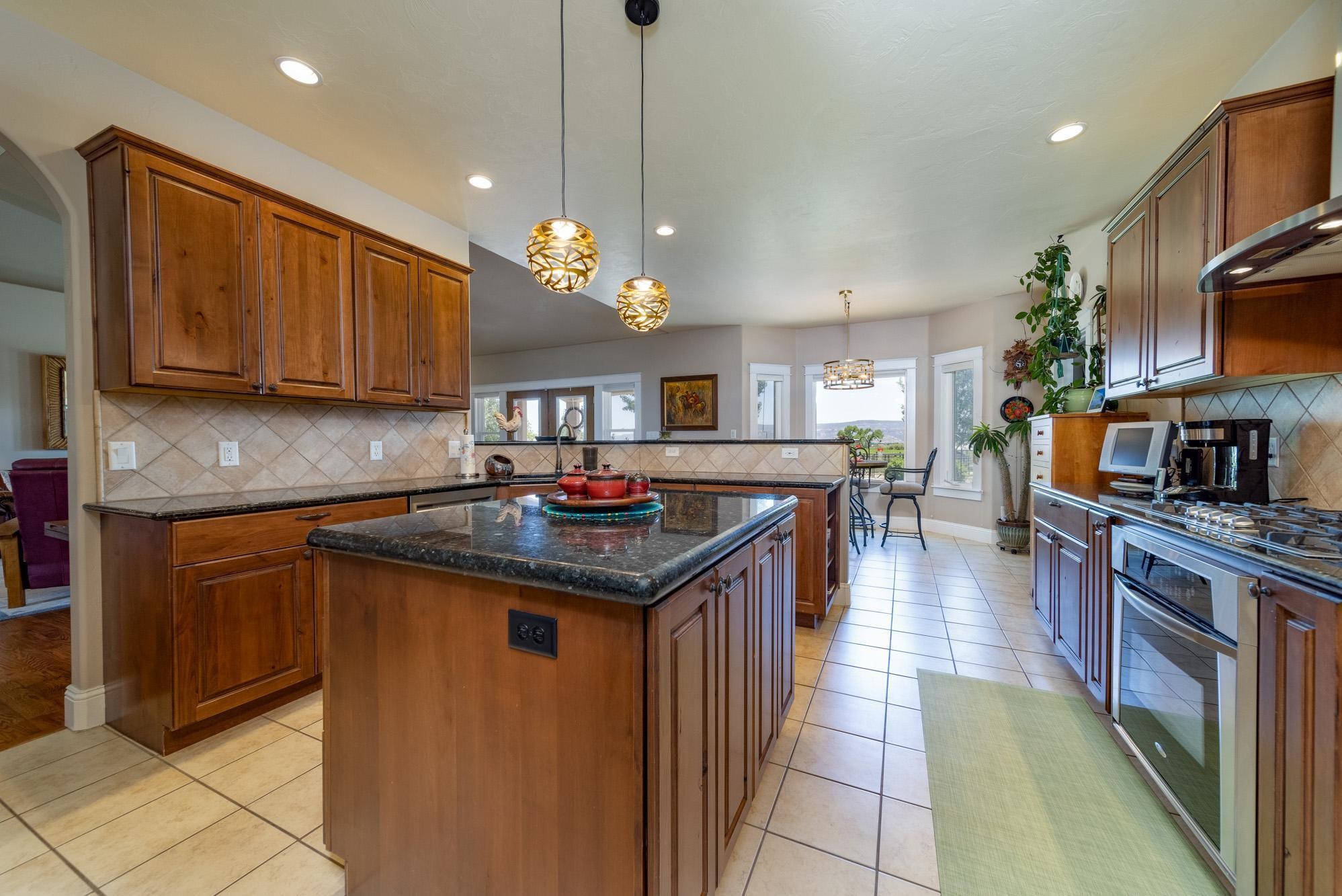 1371 Saddle Ridge Road Loma, CO 81524 - Photo 13 of 42 a kitchen with stainless steel appliances granite countertop a sink a stove top oven a counter space and cabinets