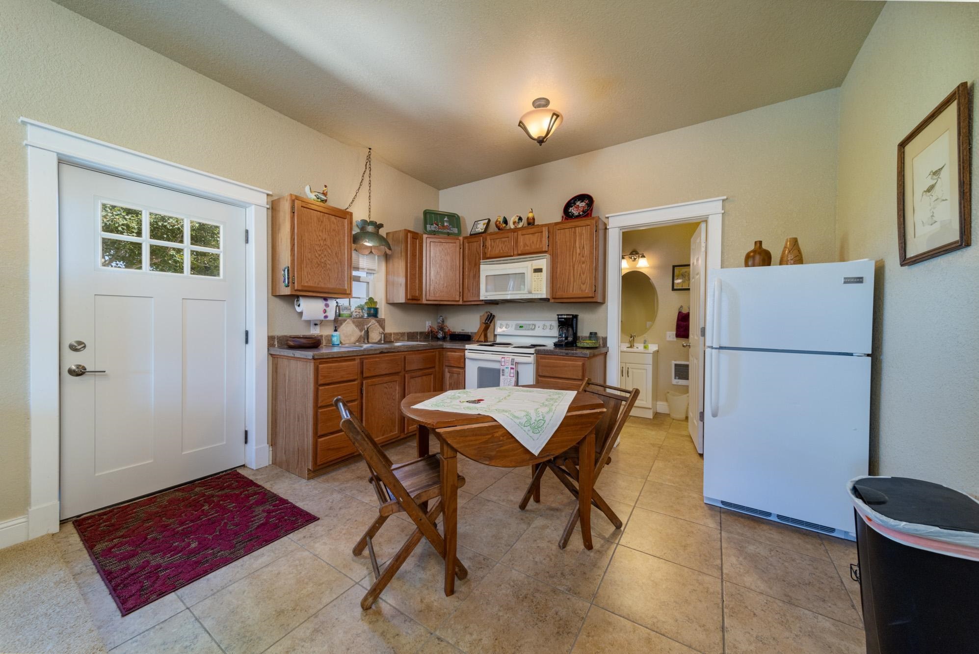 1371 Saddle Ridge Road Loma, CO 81524 - Photo 34 of 42 a kitchen with a refrigerator a table and chairs in it