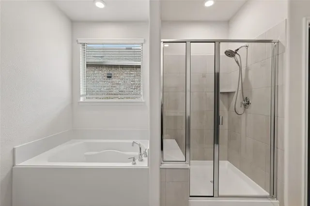 a bathroom with a sink vanity granite tub and a mirror