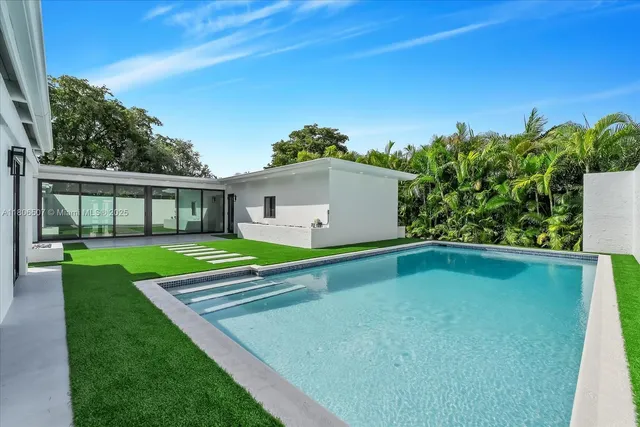 a view of an white house with a swimming pool