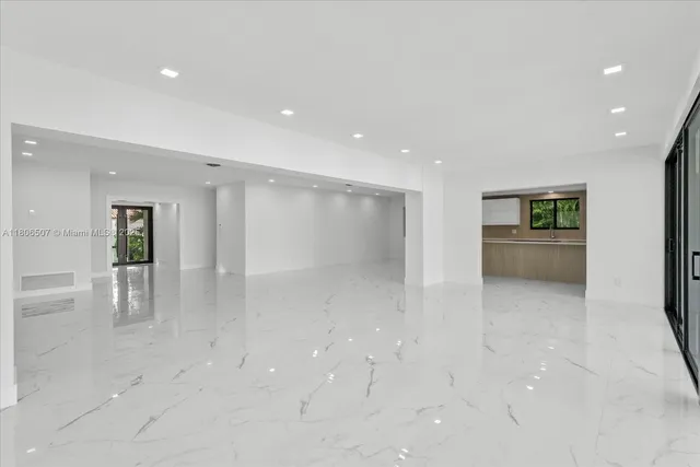 a view of an empty room with closet and a window