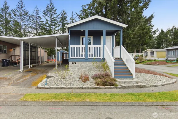 a view of a house with wooden stairs and a yard
