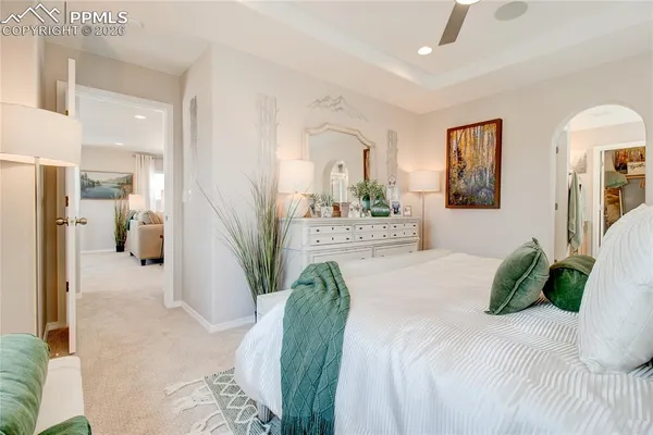 a bedroom with a bed mirror and furniture
