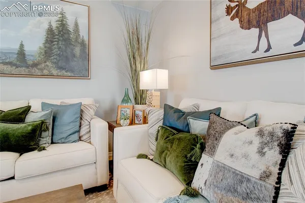 a living room with furniture and a painting on the wall