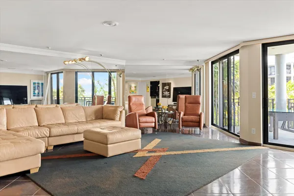 a living room with furniture a flat screen tv and a floor to ceiling window