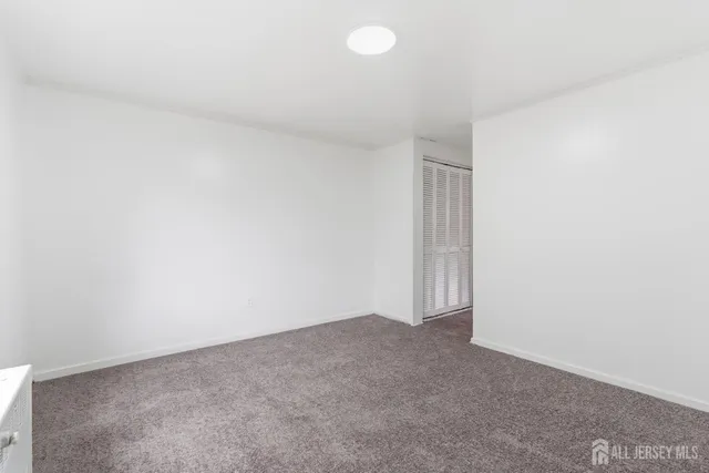 a view of an empty room and chandelier fan