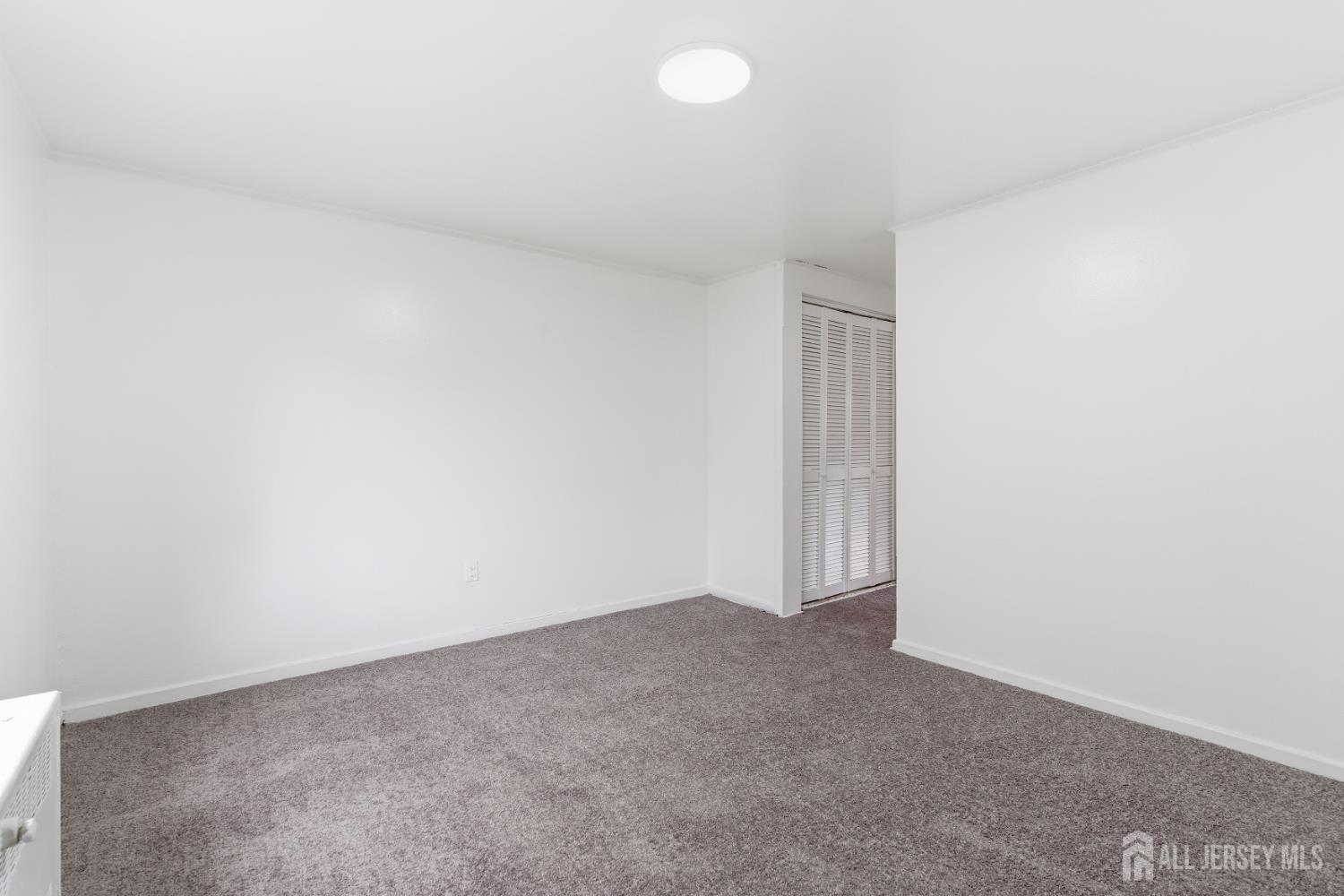 37B Garfield Park, Unit B Edison, NJ 08837 - Photo 13 of 18 a view of an empty room and chandelier fan