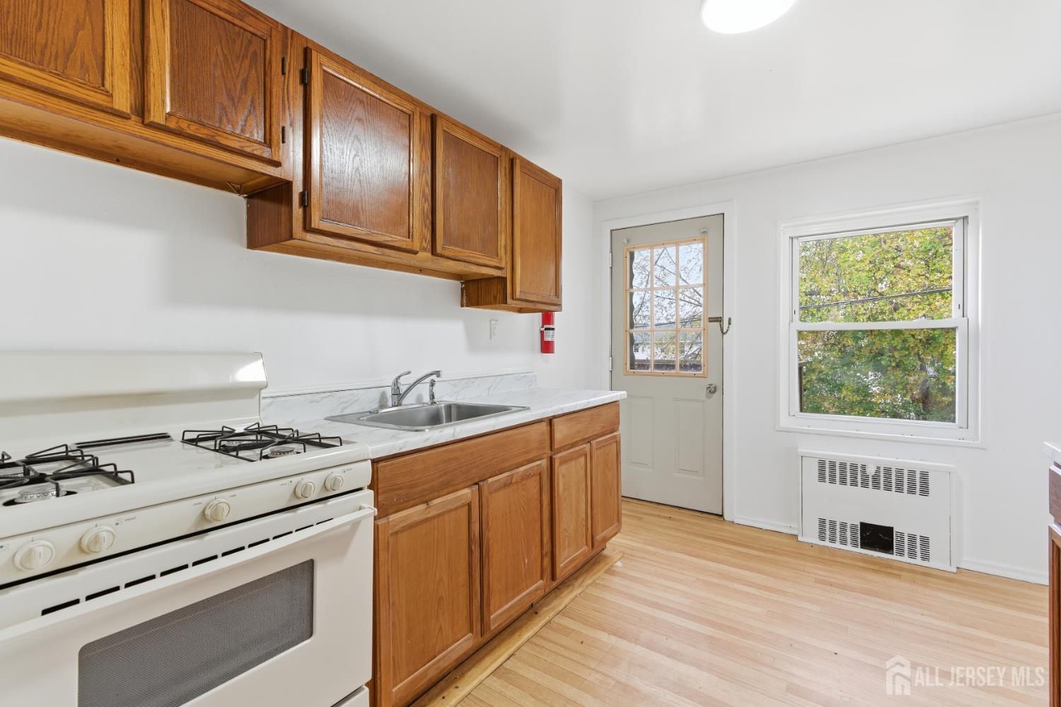 37B Garfield Park, Unit B Edison, NJ 08837 - Photo 8 of 18 a kitchen with stainless steel appliances granite countertop a stove a sink and a microwave