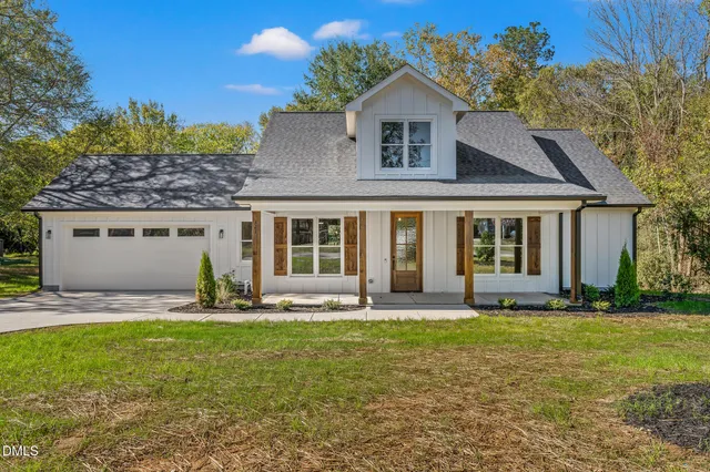 a front view of a house with a yard and outdoor seating