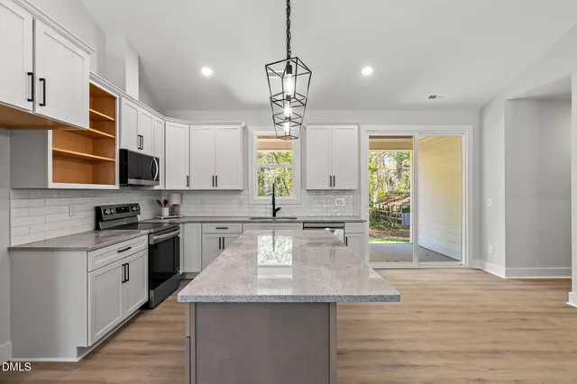 a kitchen with stainless steel appliances granite countertop a sink a stove top oven a counter space and cabinets