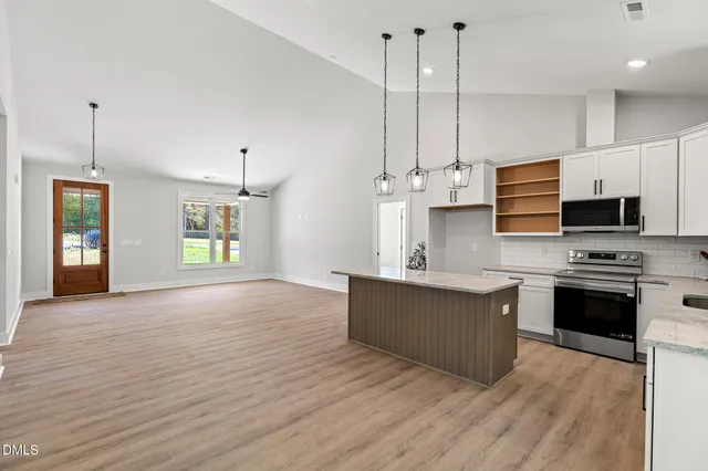 a kitchen with stainless steel appliances granite countertop a stove and a wooden floors