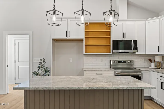 a kitchen with stainless steel appliances granite countertop a sink a stove and dishwasher with wooden floor