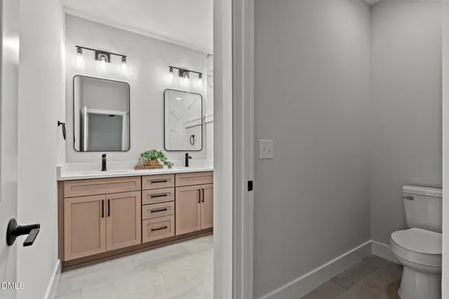 a spacious bathroom with a toilet sink and mirror