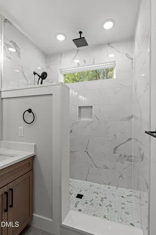 a bathroom with a sink a mirror and shower