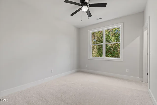 an empty room with a window and a fan