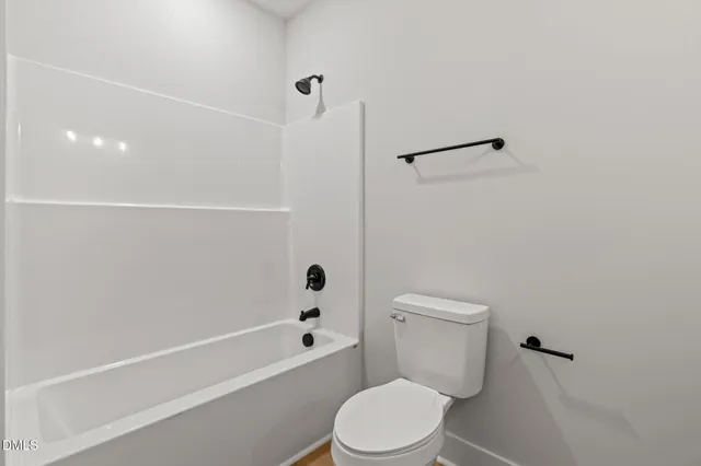 a white toilet sitting next to a bath tub