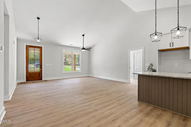 a view of an empty room with window and wooden floor