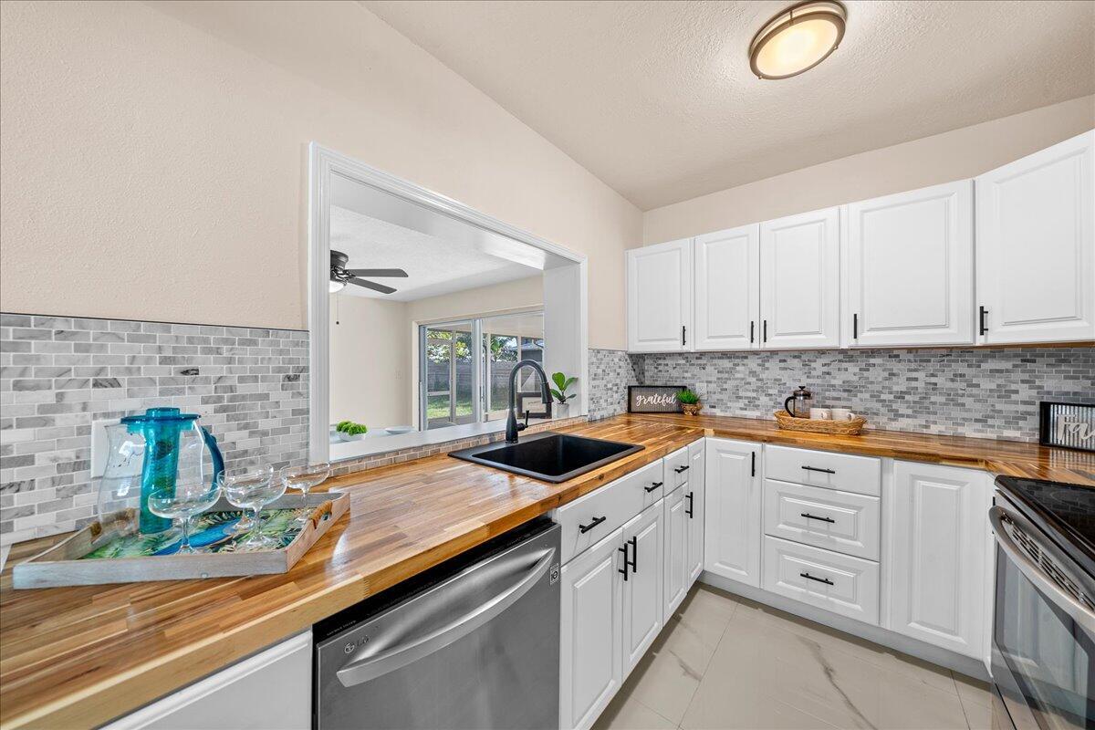 a kitchen with granite countertop a sink and white cabinets