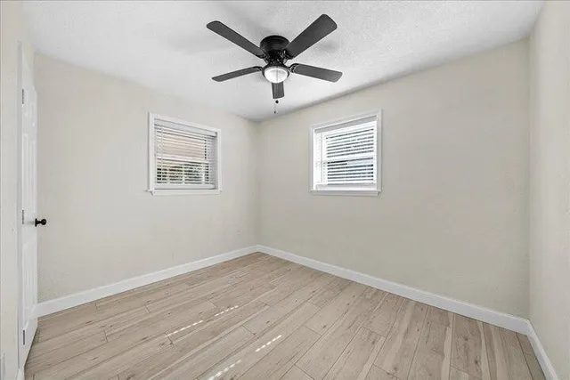 a view of empty room with wooden floor