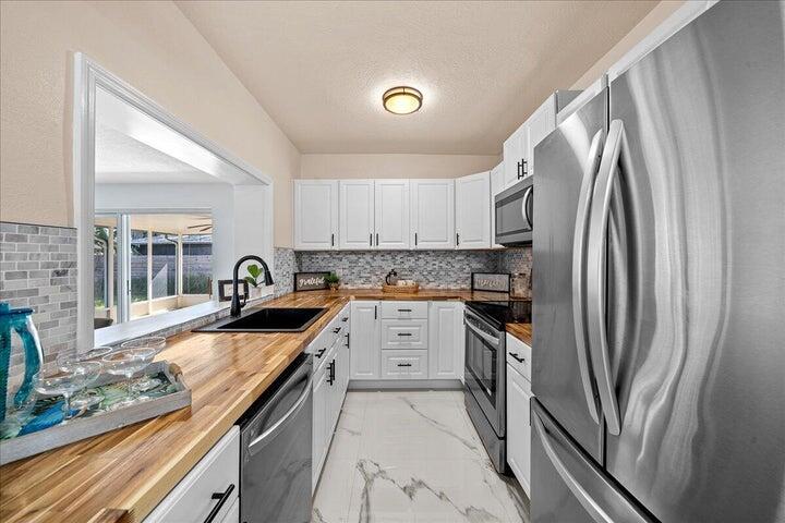 3401 Purdue Street Melbourne, FL 32901 - Photo 7 of 19 a kitchen with granite countertop a sink stove and refrigerator