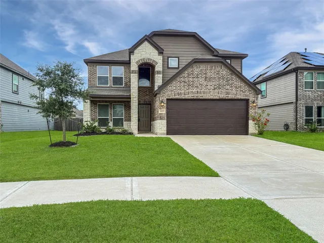 a front view of a house with a yard and garage
