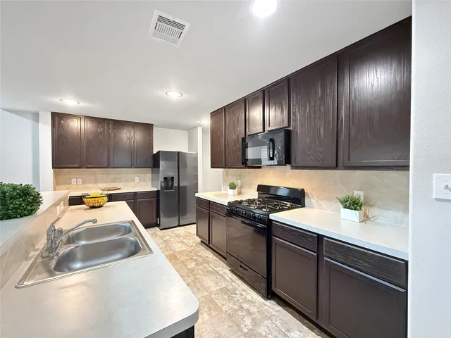 a kitchen with stainless steel appliances granite countertop a sink stove and cabinets