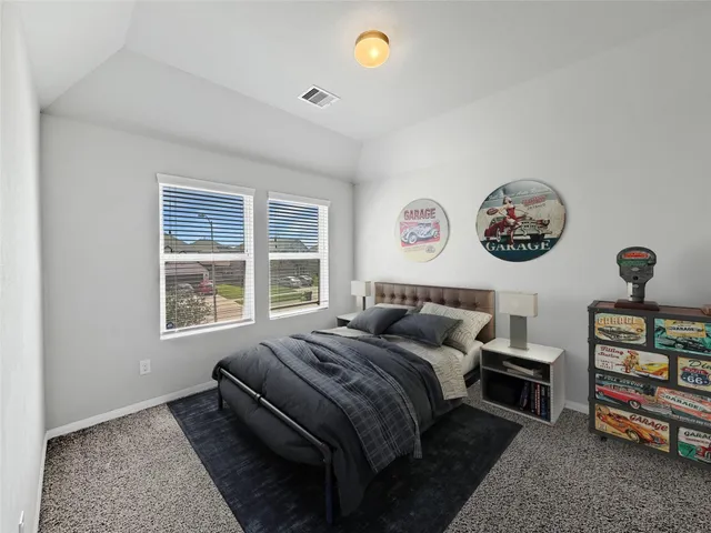 a bedroom with a bed a dresser and a window