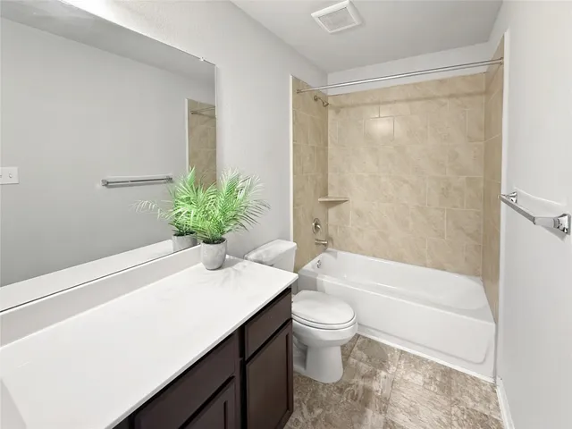 a bathroom with a granite countertop sink a toilet and bathtub