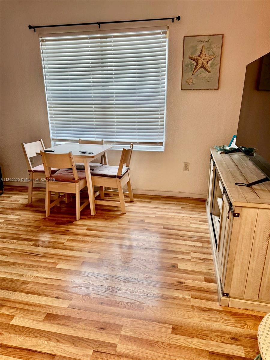 7326 Collins Avenue, Unit 105 Miami Beach, FL 33141 - Photo 6 of 13 a view of a room with furniture and wooden floor