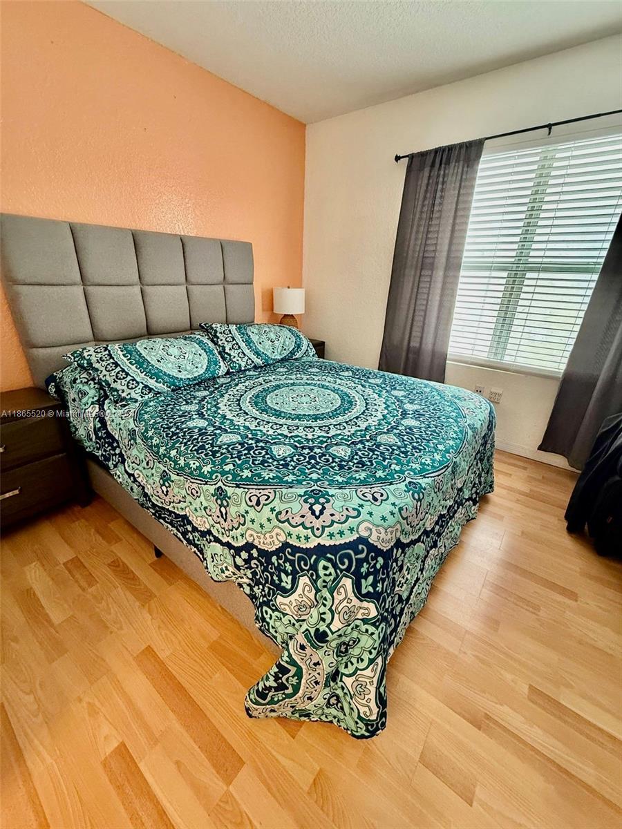 7326 Collins Avenue, Unit 105 Miami Beach, FL 33141 - Photo 8 of 13 a bed sitting in a bedroom next to a window