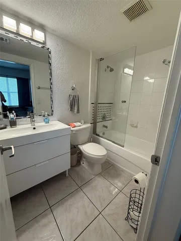 a bathroom with a double vanity sink toilet mirror and shower