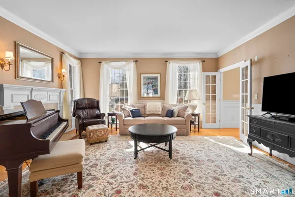 a living room with furniture a flat screen tv and a floor to ceiling window