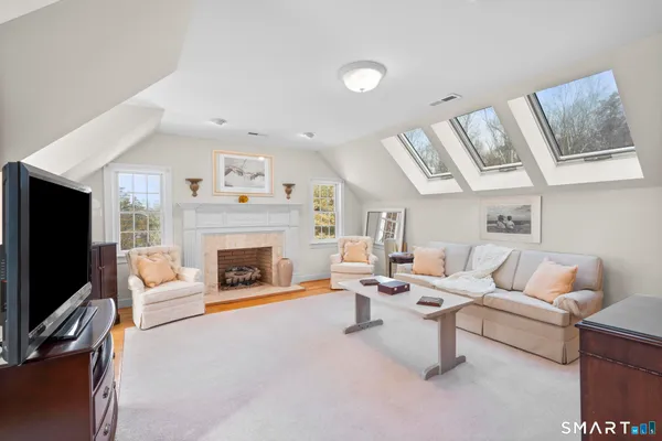 a living room with furniture a flat screen tv and a fireplace
